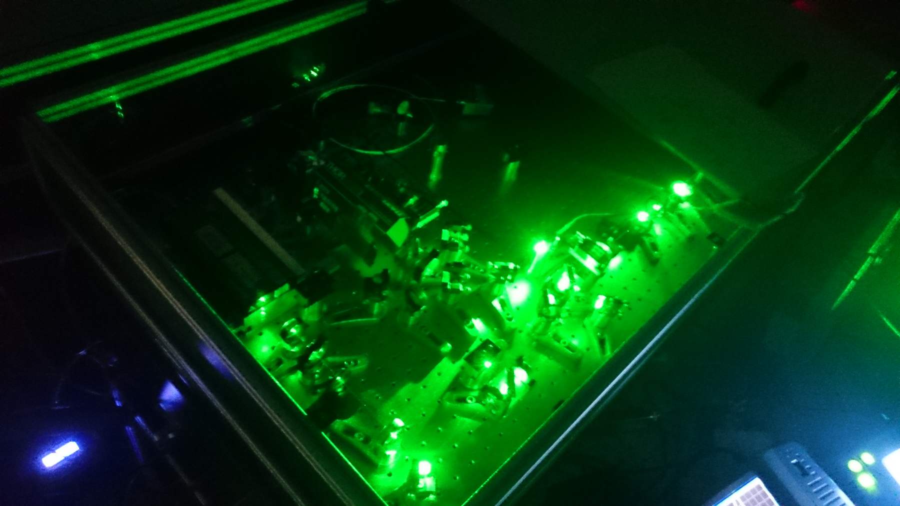 Optical table lit by green laser light